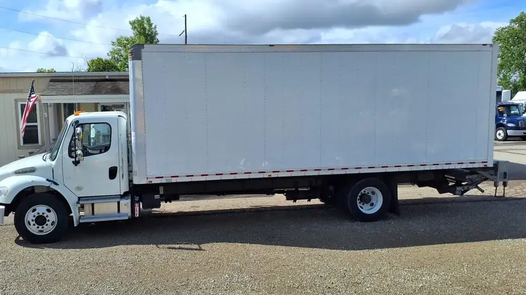 White box truck parked under a blue sky